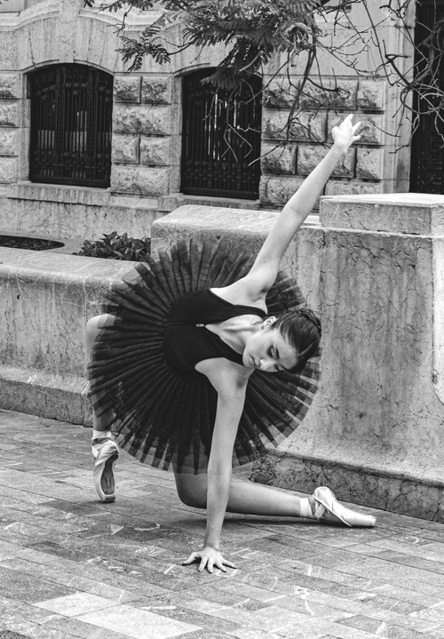 Free Black and white photo of a ballerina in a tutu dancing on a sidewalk in Mexico City. Stock Photo