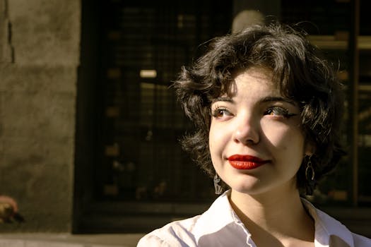 Close-up portrait of a woman with red lipstick smiling in the sunlight, Mexico City.