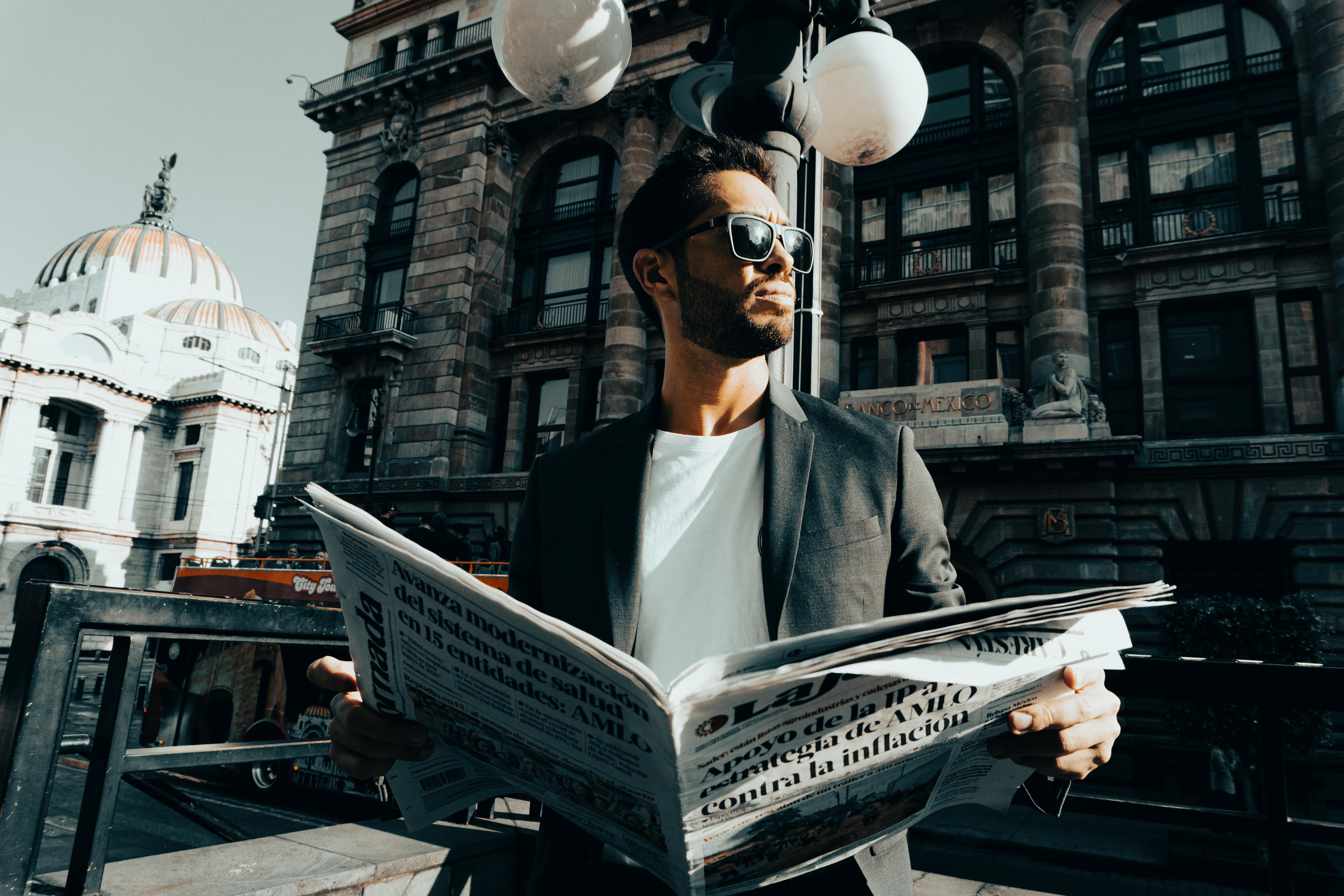 bearded man holding newspaper