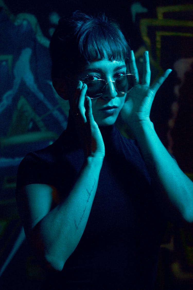 Woman In Sunglasses In Blue Light In Dark