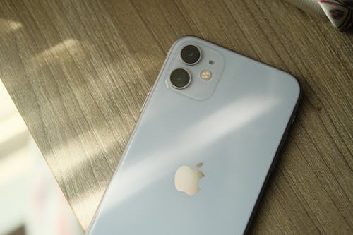 Free Silver iPhone on Brown Wooden Surface Stock Photo
