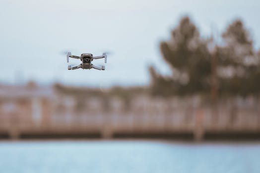 A modern drone flying over water with blurred background. Captures outdoor technology in action.