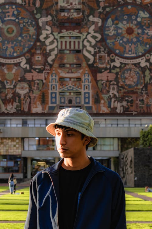 Photo of a Young Man against the Background of the Building of the National Autonomous University of Mexico