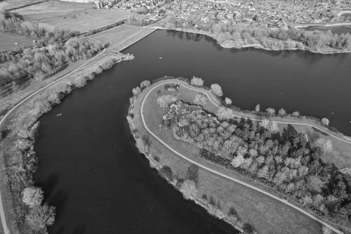 Free A captivating aerial shot of a lake and rural landscape in black and white, showcasing natural beauty. Stock Photo