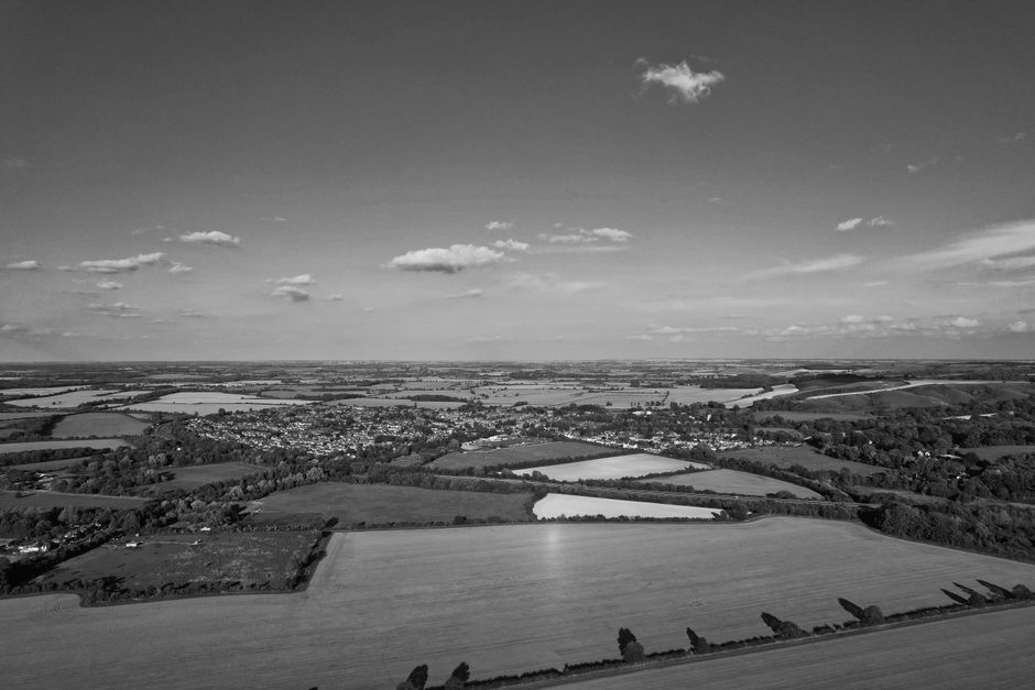 Incredible 25 Minute Kent Heritage Helicopter Tour Review: Soaring Over England's Garden from Above Review 2026 - Stunning aerial view of English countryside with fields, forests, and small village in black and white.