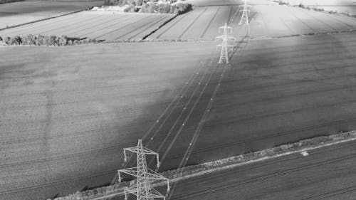 Free Black and White Photo of Electric Towers on a Field Stock Photo