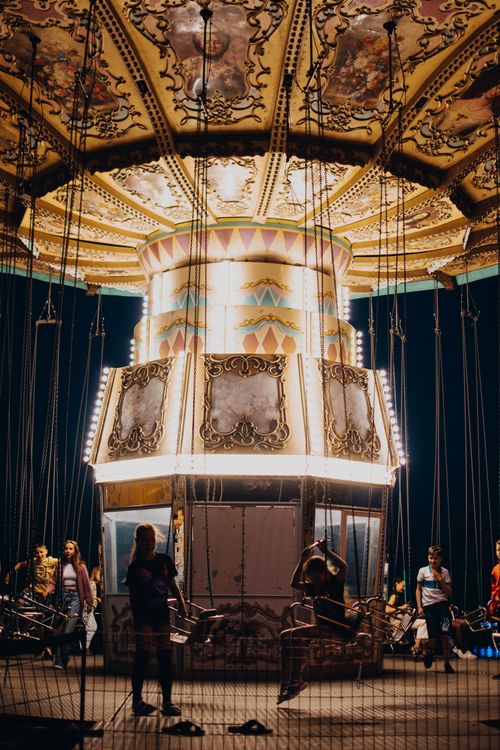 Free Enjoying a lively night with friends on a carousel ride at the amusement park. Stock Photo