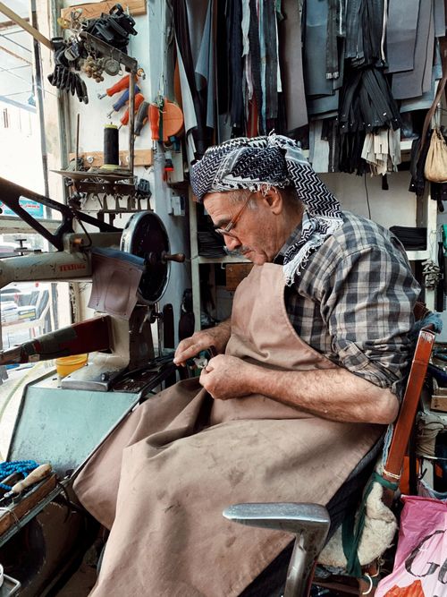 Free A senior craftsman focuses on leatherwork in a traditional workshop, highlighting a dying art form. Stock Photo