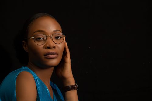 Free A striking studio portrait of a woman with eyeglasses, exuding elegance and style. Stock Photo