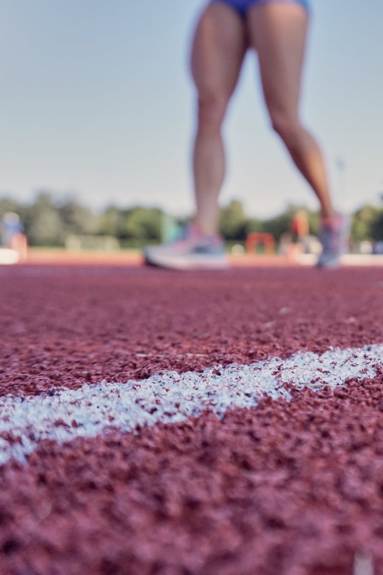 Person Wearing Running Shoes On Running Field