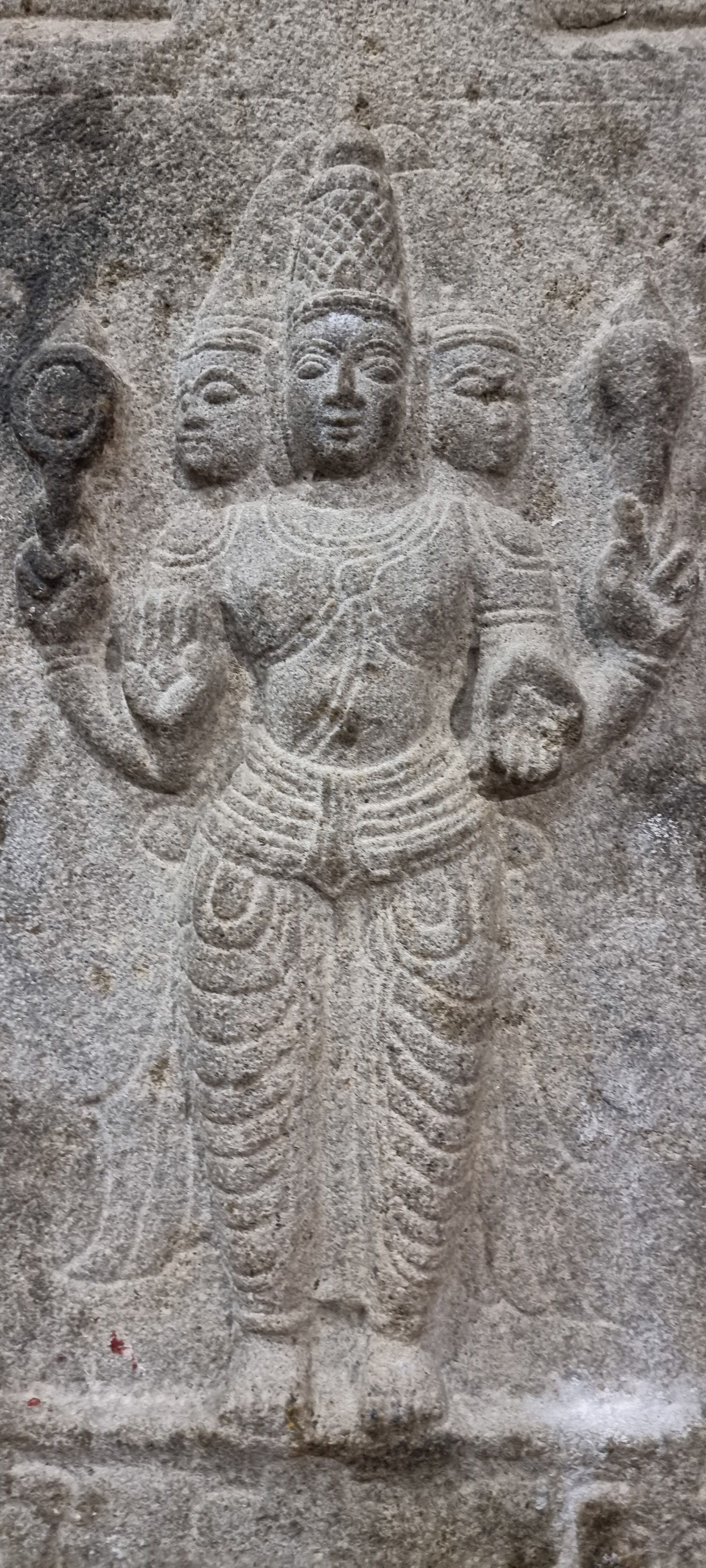 Intricately carved stone relief of a Hindu deity in Tiruvannamalai temple.