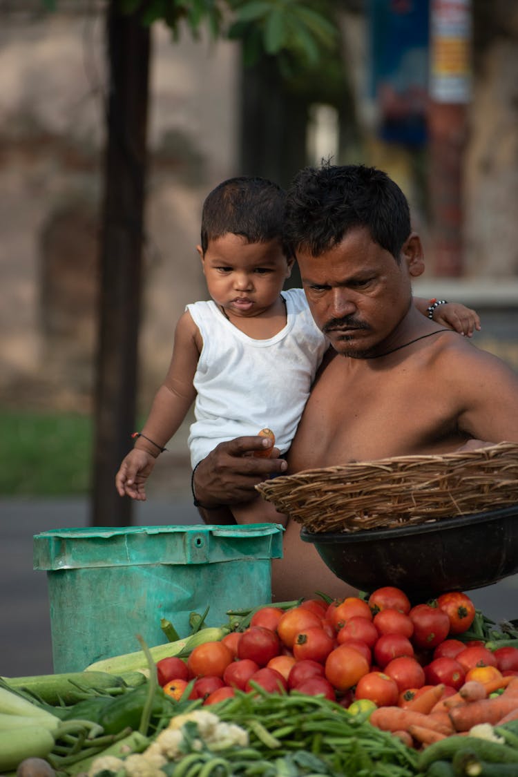 Man Carrying His Son On A Fresh Food Market 