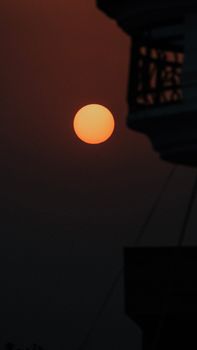 Serene silhouette of a balcony against a vibrant sunset in town.