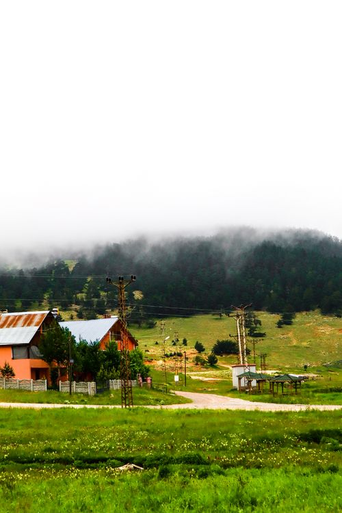 Free Serene rural landscape with fog over a village, capturing tranquil countryside vibes. Stock Photo