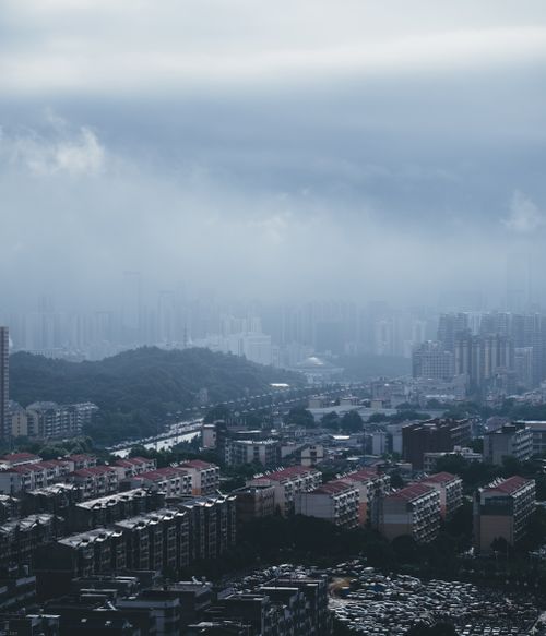 Free High-angle view of a fog-covered urban cityscape under an overcast sky, conveying a moody atmosphere. Stock Photo