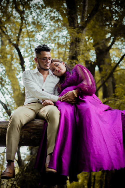 Free An expectant couple sitting together outdoors, embracing with love and affection. Stock Photo