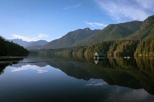 Free Serene landscape of a lake reflecting mountains and trees in Vancouver, British Columbia. Stock Photo