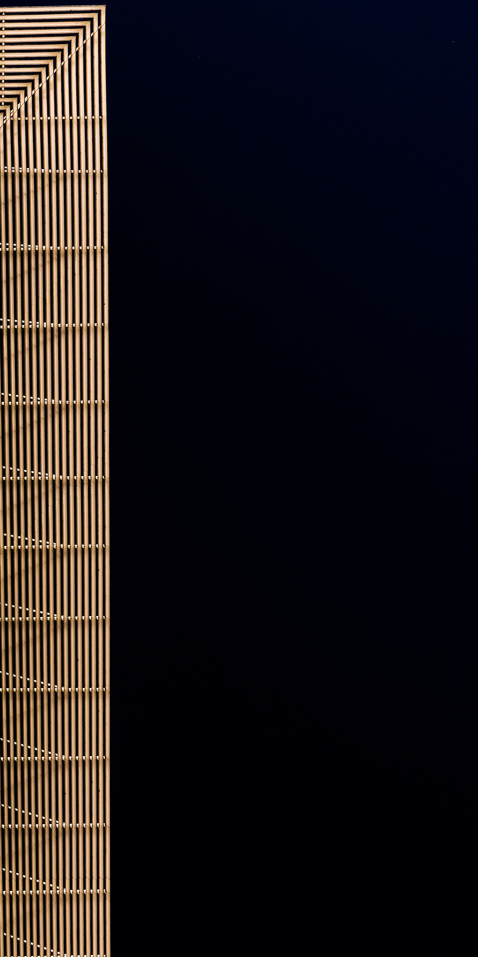 A sleek modern building with minimalistic design captured at night against a dark sky.