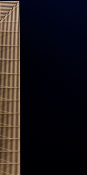 A sleek modern building with minimalistic design captured at night against a dark sky.
