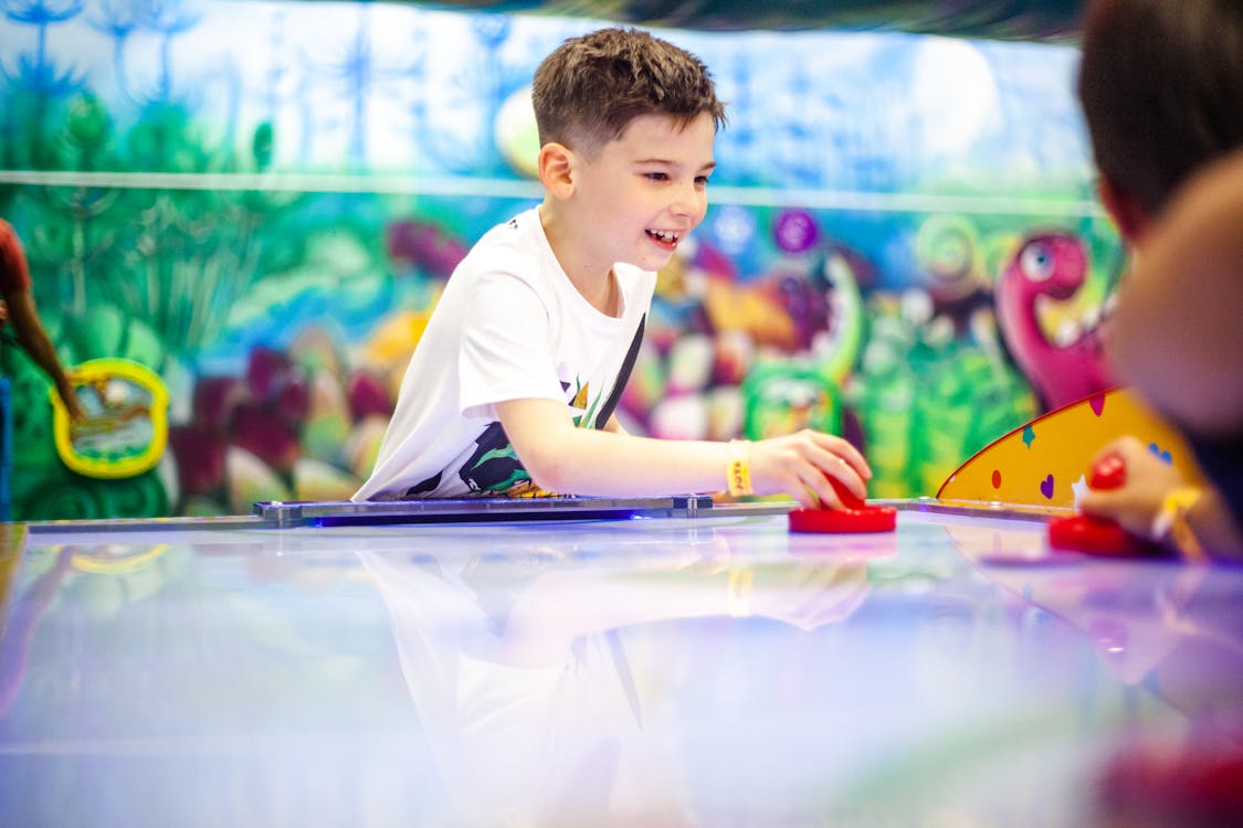 Free Photo of a Boy in a White Shirt Playing Table Hockey  Stock Photo