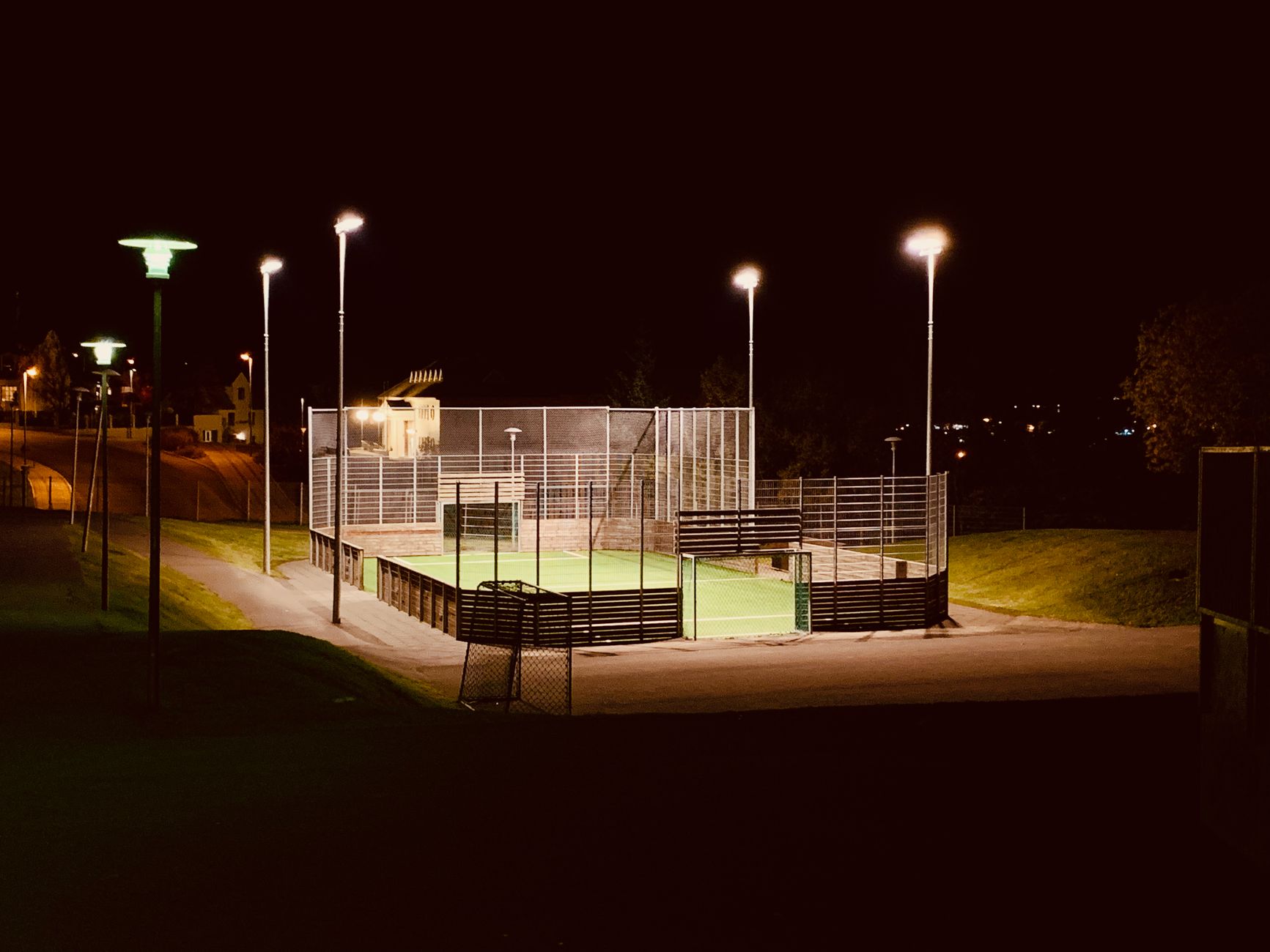 Scenic view of a brightly lit football field in Akureyri, Iceland, during a calm night.
