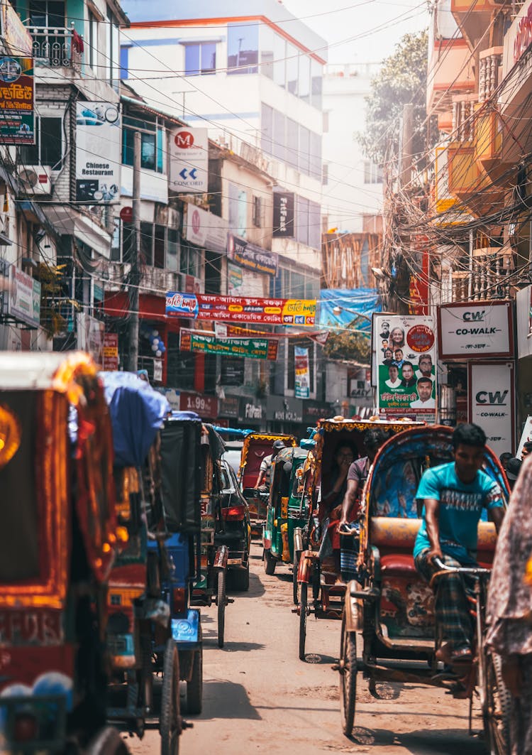 People Riding Rickshaws On The Street