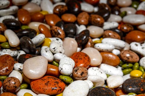 Free A close-up shot showcasing a variety of colorful decorative stones and pebbles, ideal for design and decoration themes. Stock Photo