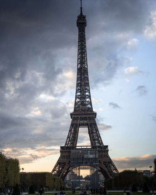 Free A dramatic view of the Eiffel Tower in Paris at twilight with moody clouds. Stock Photo