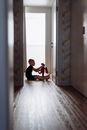 Man in Red T-shirt and Black Pants Sitting on Floor
