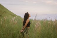 Girl with Long Brown Hair Standing in Grassland