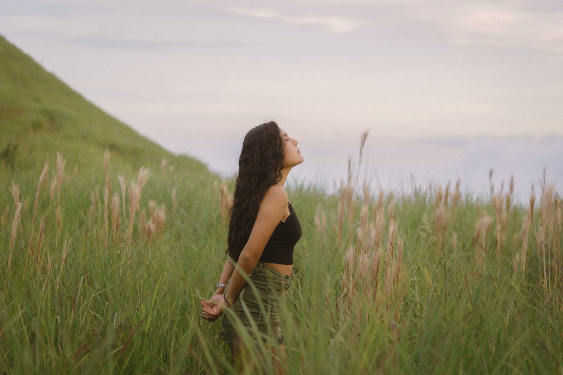 Free Girl with Long Brown Hair Standing in Grassland Stock Photo