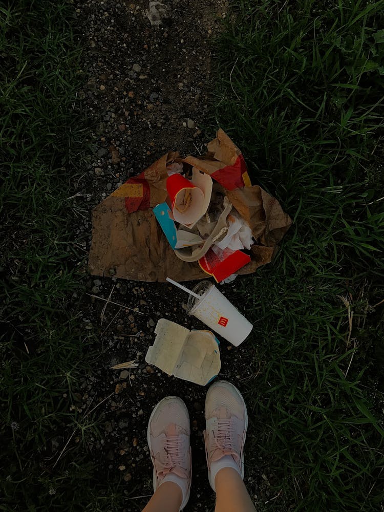 Shoes On Grass And Fast Food Trash