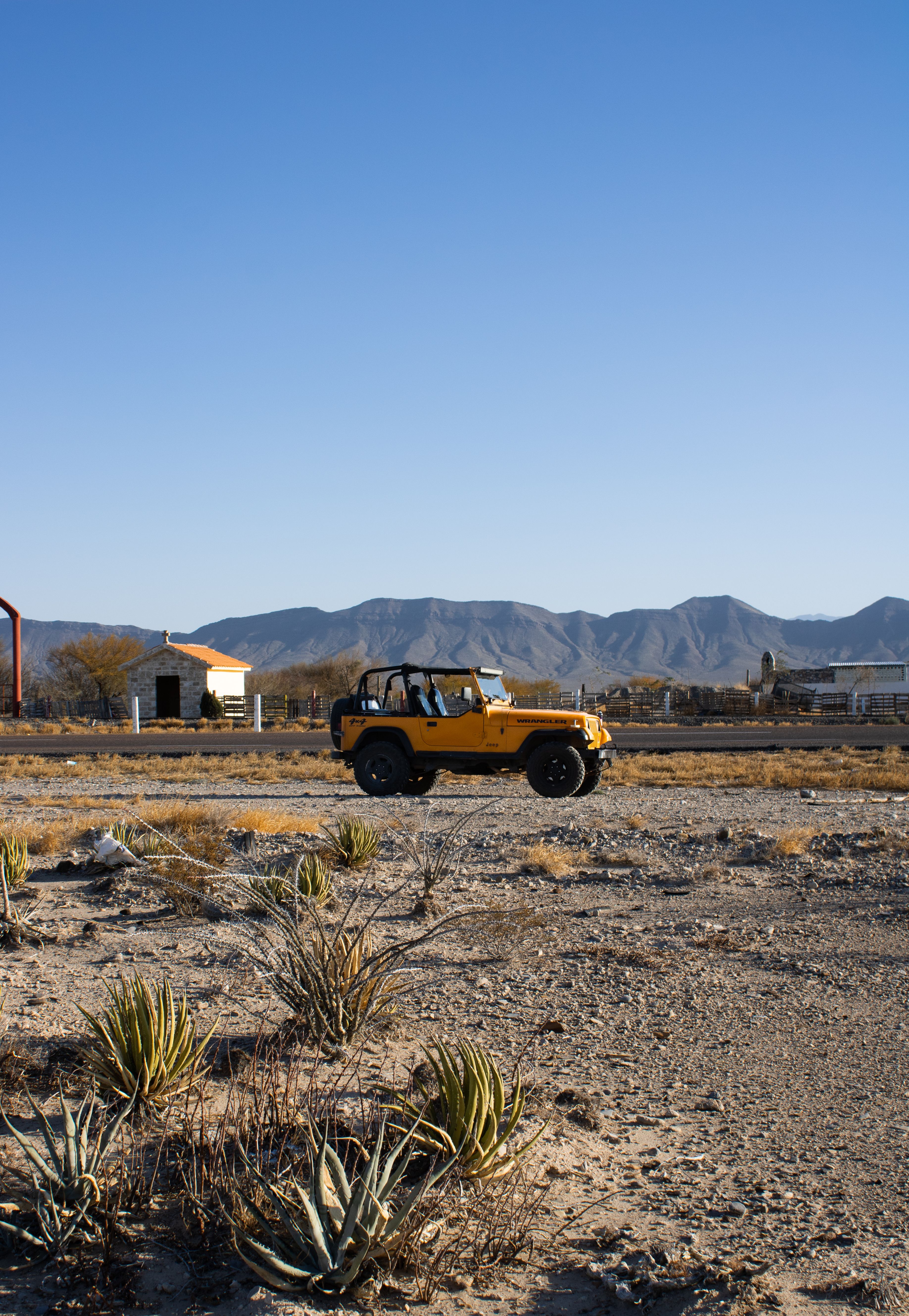 A yellow Jeep parked in the desert landscape of Parras de la Fuente, Mexico.