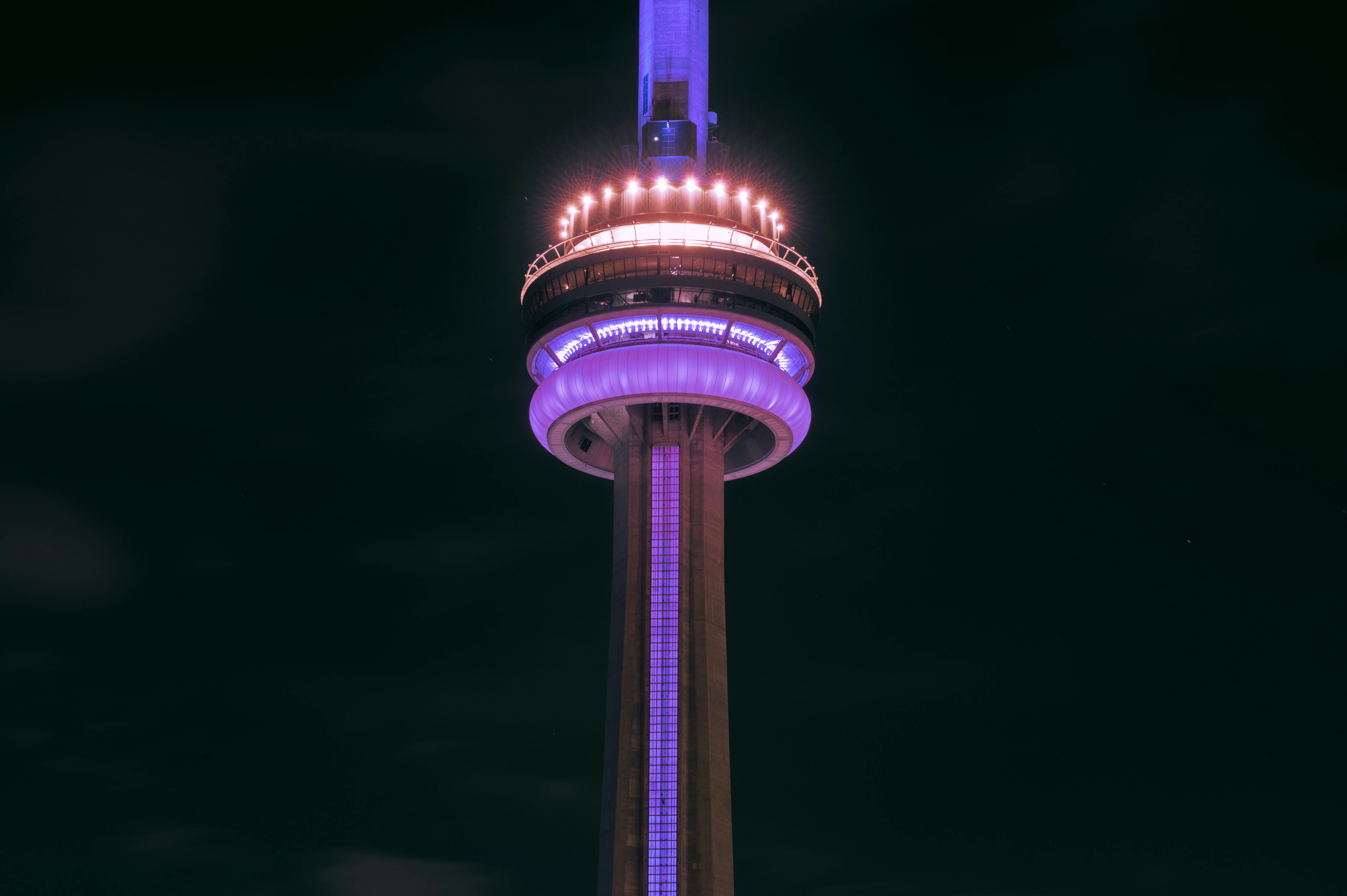 Close-up of the CN Tower beautifully illuminated at night against a dark sky in Toronto, Canada.