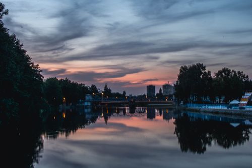 Free Peaceful sunset reflection on the Malše River in České Budějovice, Czechia. Stock Photo