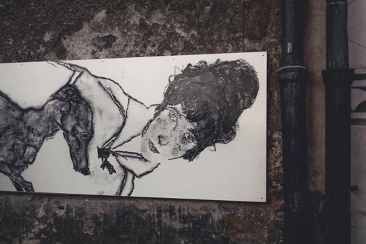 Street art depicting a woman and a dog on a textured wall in Český Krumlov.