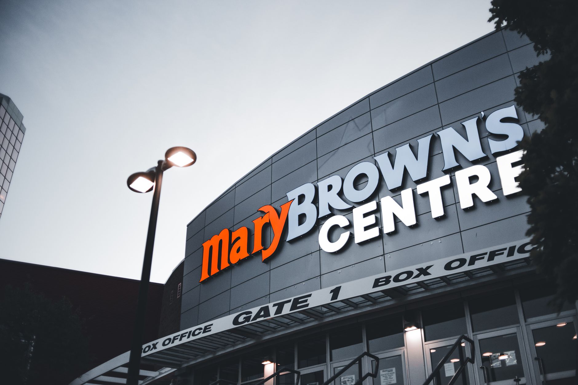 View of Mary Brown's Centre entrance facade during twilight with clear signage visible.