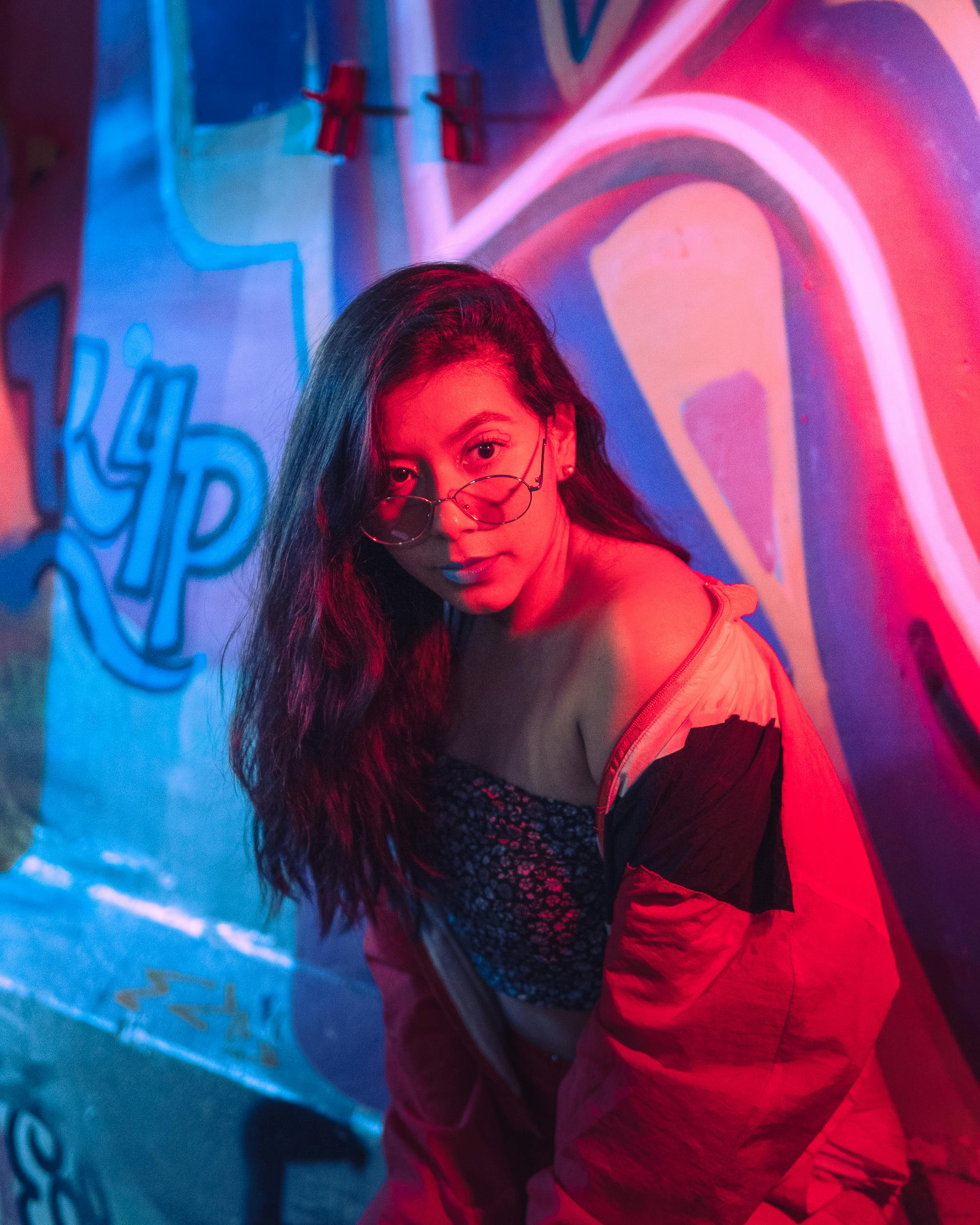 Woman with Dyed Hair Sitting by Motel Logo · Free Stock Photo