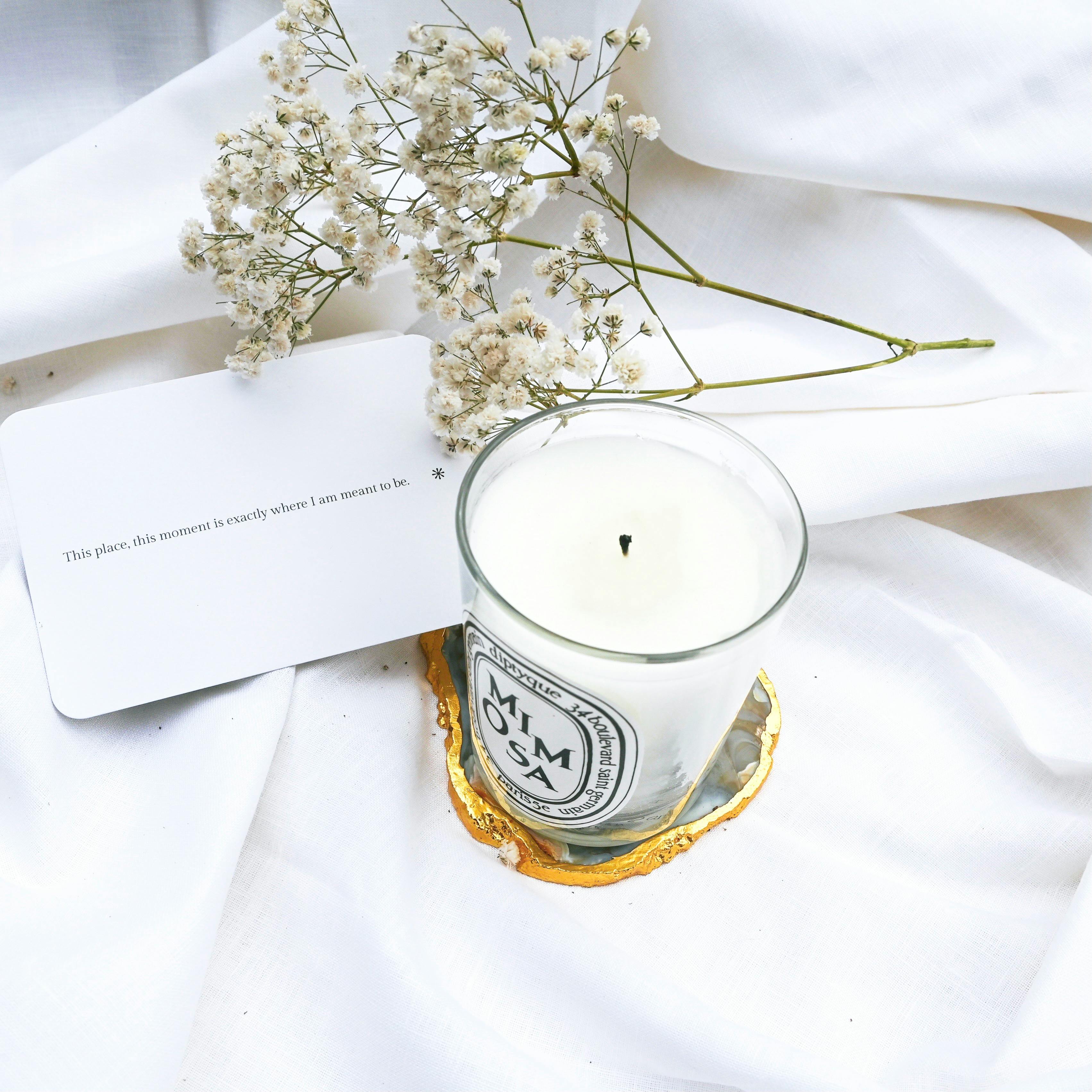 A White Candle Near Baby's Breath Flowers · Free Stock Photo