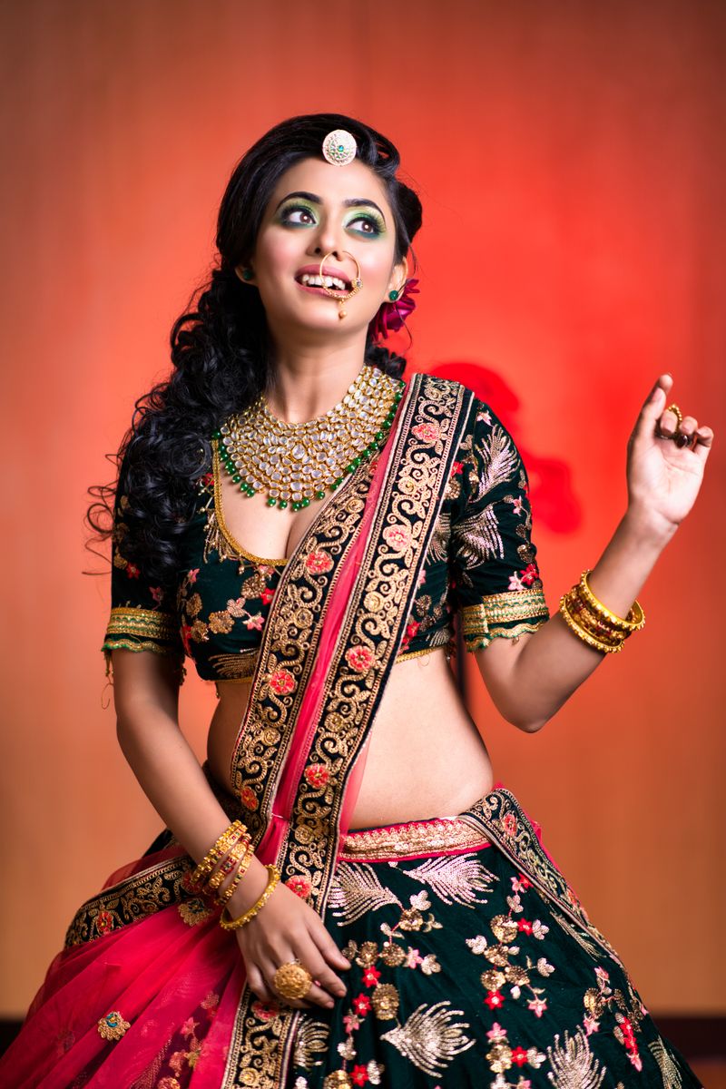 Portrait of a young Indian woman in traditional saree with elegant jewelry, smiling.