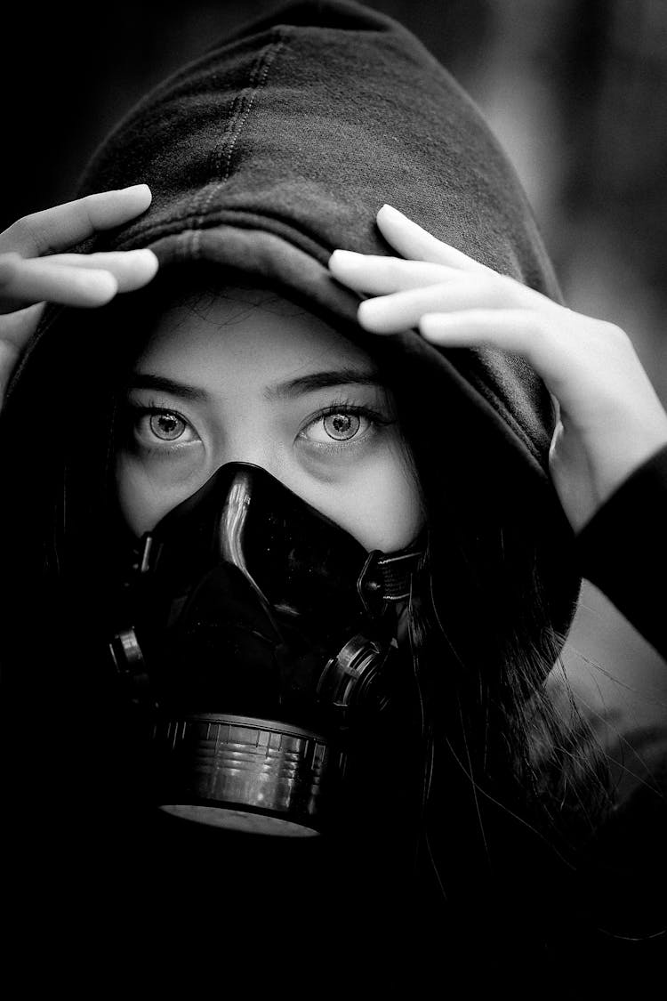 A Woman In Hoodie  Wearing A Gas Mask 