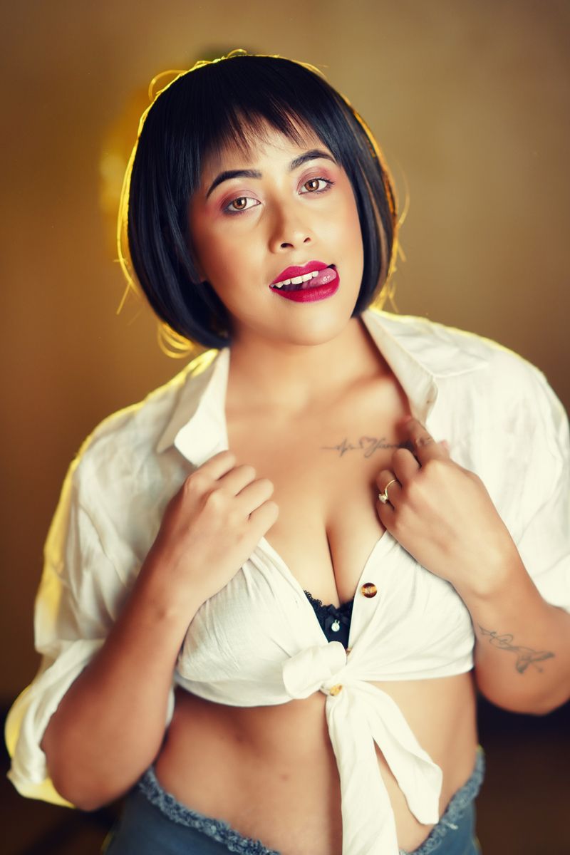 Stylish portrait of a young woman with confident pose and modern attire in a studio setting.