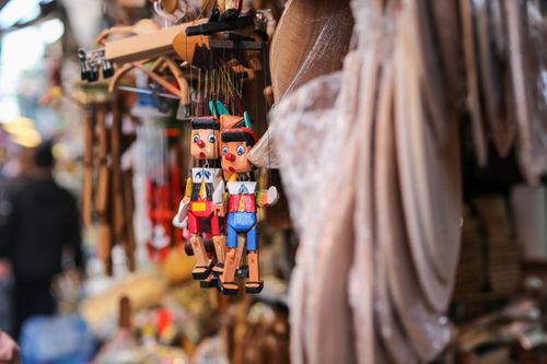 Free Close-up of colorful wooden marionettes hanging in a lively İstanbul market. Stock Photo