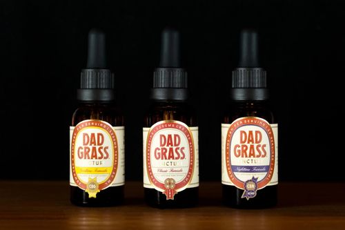 Free Three bottles of Dad Grass tincture showcasing different formulas on a black background. Stock Photo