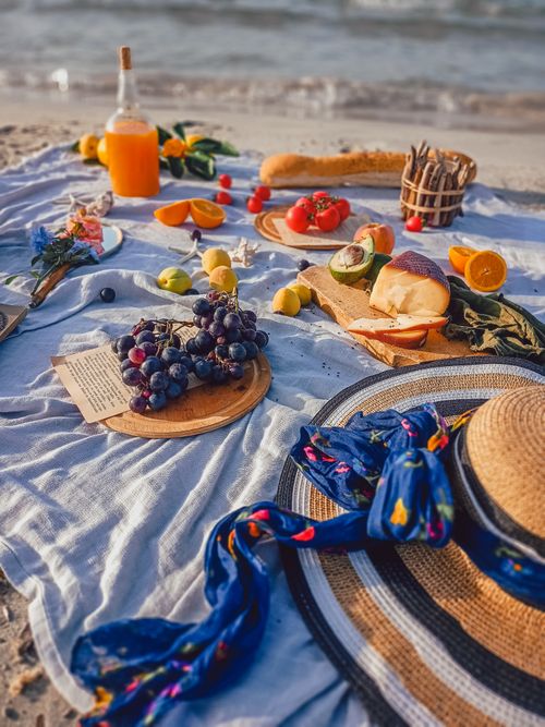 Free A vibrant beach picnic in Turkey featuring fresh fruits, bread, and a summer hat on a sunny day. Stock Photo