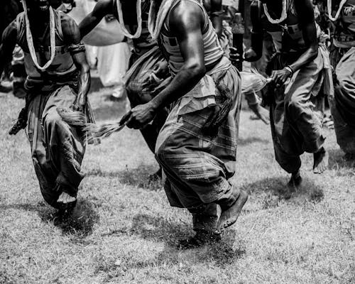 Grayscale Photo of People on Grass Field