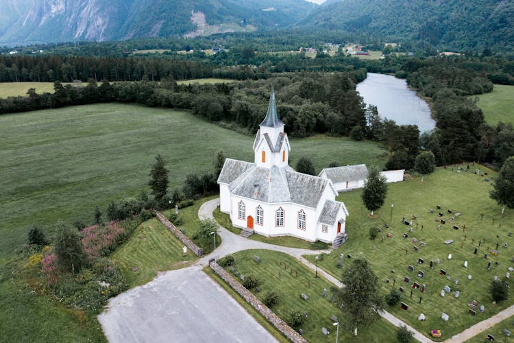 Aerial View Of White Church And Cemetery In Mountains