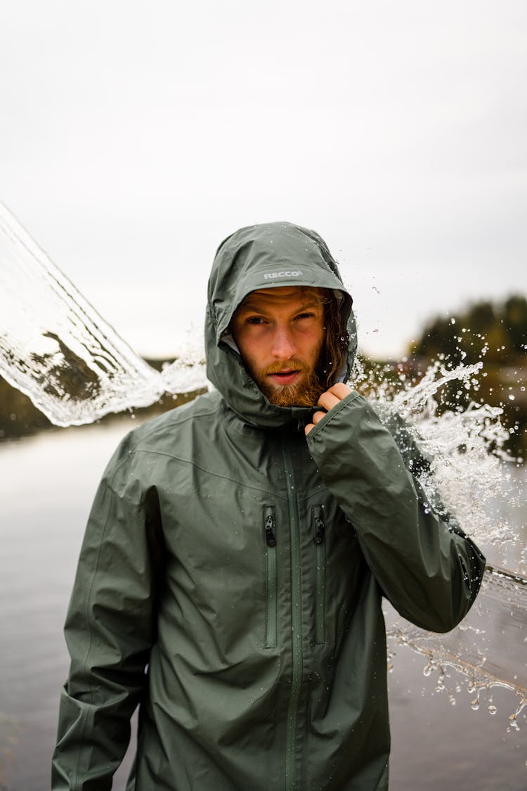 Water Poured Over Bearded Man In Hooded Waterproof Jacket