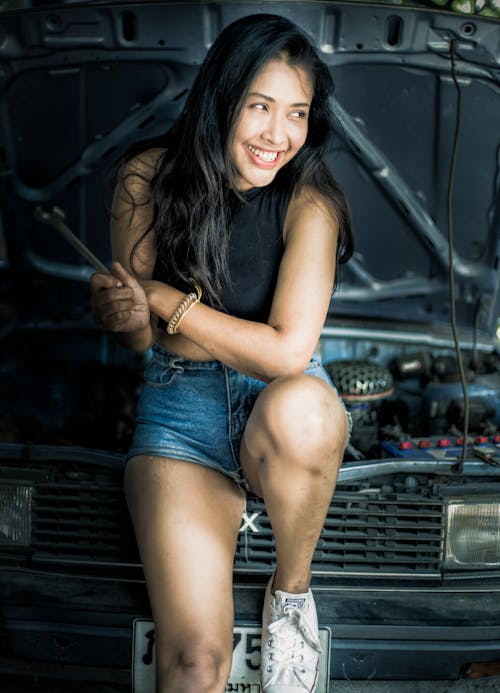 Woman Smiling While Holding a Wrench