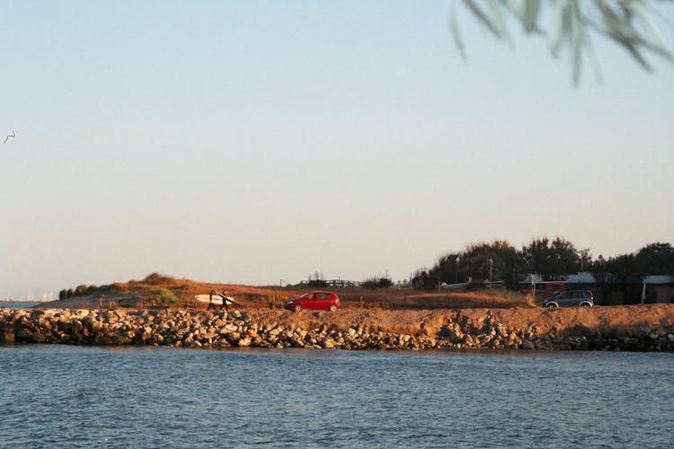 Surfers Walking To The Red Car